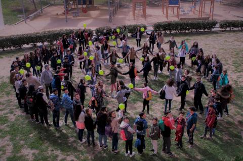 Fotografia aèrea d'una trobada de la XAJI on es veu un grup nombrós de joves agafats de les mans reproduïnt el logotip del projecte
